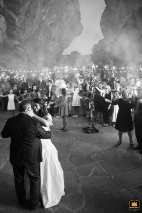 Bride and groom share a romantic dance on a smoke-filled dance floor surrounded by sparklers at Morrison Amphitheater in Colorado, resembling a slot cave under the open sky.